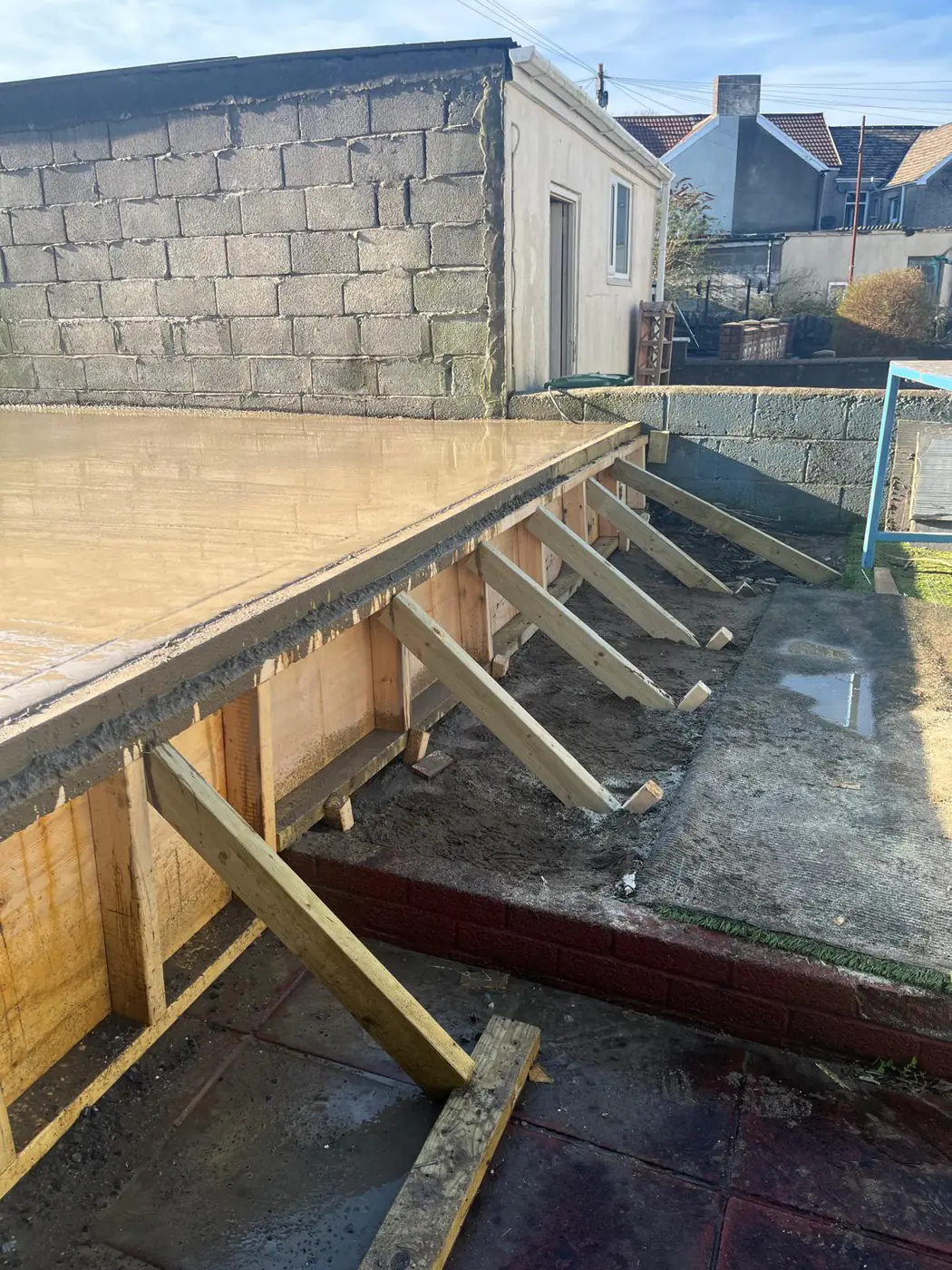 Cantilevered base edge supported on timber props