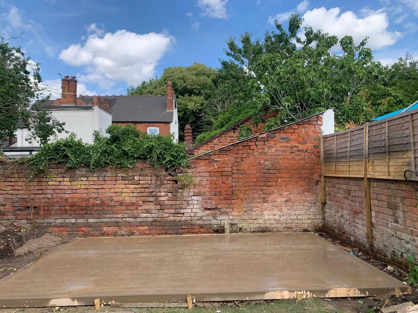 Freshly poured base against a period brick wall