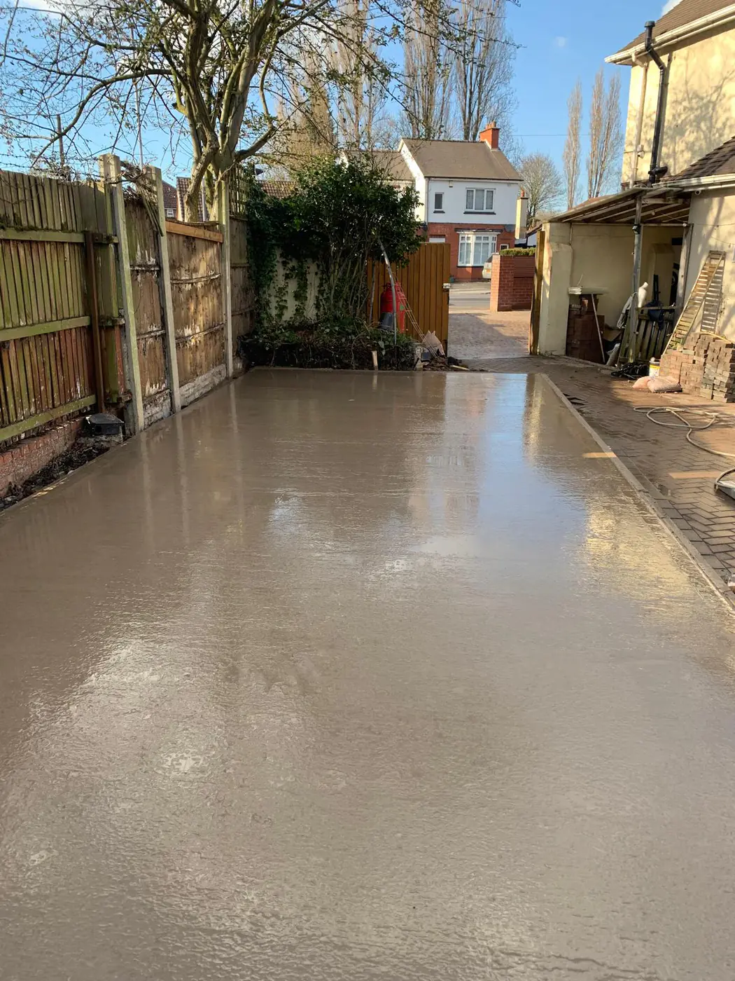 Freshly poured base along a side driveway