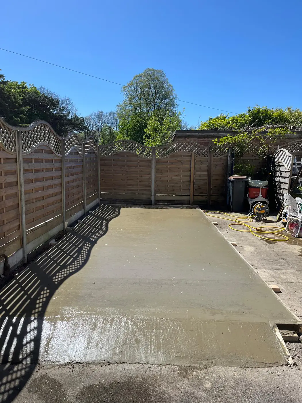 Freshly poured base enclosed by trellis fencing