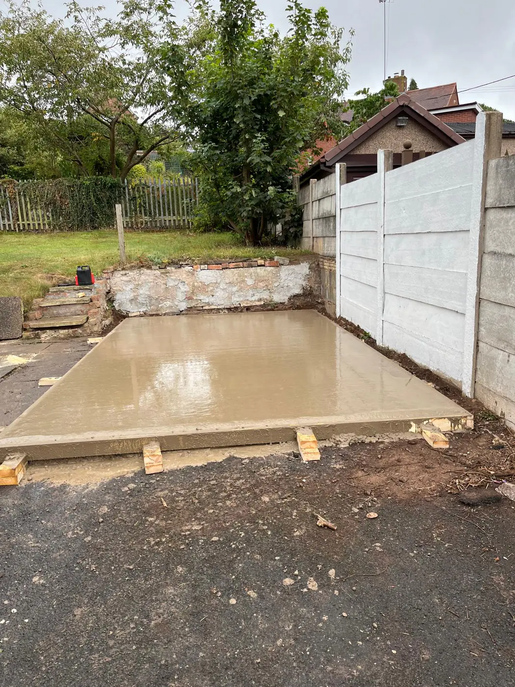 Freshly poured base beside a bungalow
